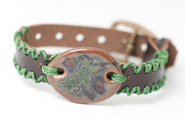 Dünnes Armband mit Medaillon und Garn. Verschluss: Schnalle Bild