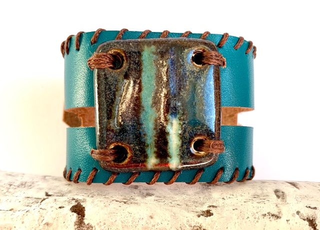 Breites Armband mit großem Medaillon. Verschluss: Druckknöpfe Bild